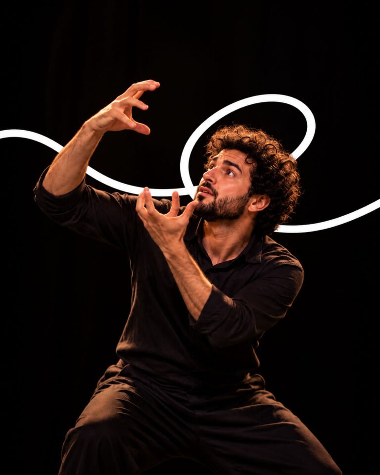 A performer signing with dramatic gestures under a spotlight